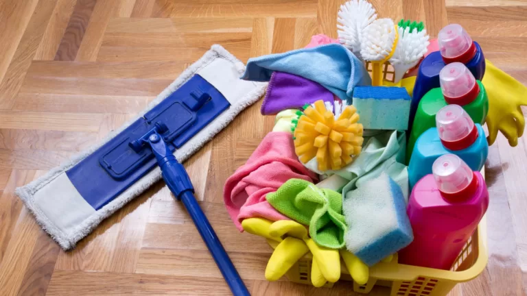 a mop and colourful cleaning products on the floor